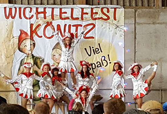Das Bild zeigt eine gut gelaunte Tanztruppe auf einer Bühne beim Wichtelfest Könitz.