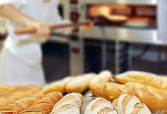 Das Bild zeigt unterschiedliche frisch gebackene Baguette auf einem Tisch in der Backstube.