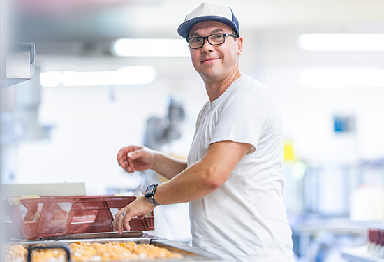 Auf dem Bild schaut dich der Leiter der Konditorei an, der gerade Plattenkuchen für den Verkauf fertigstellt.